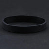 A black silicone elastic wristband is shown against a dark background.