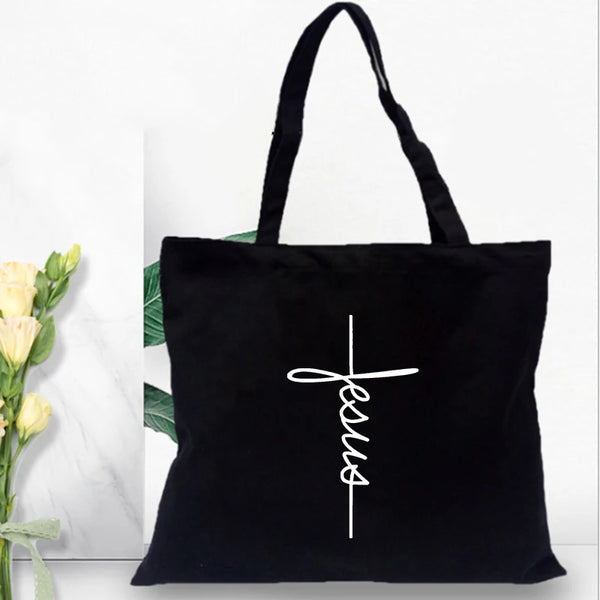 Sac en toile noire avec un motif croix blanche imprimé.
