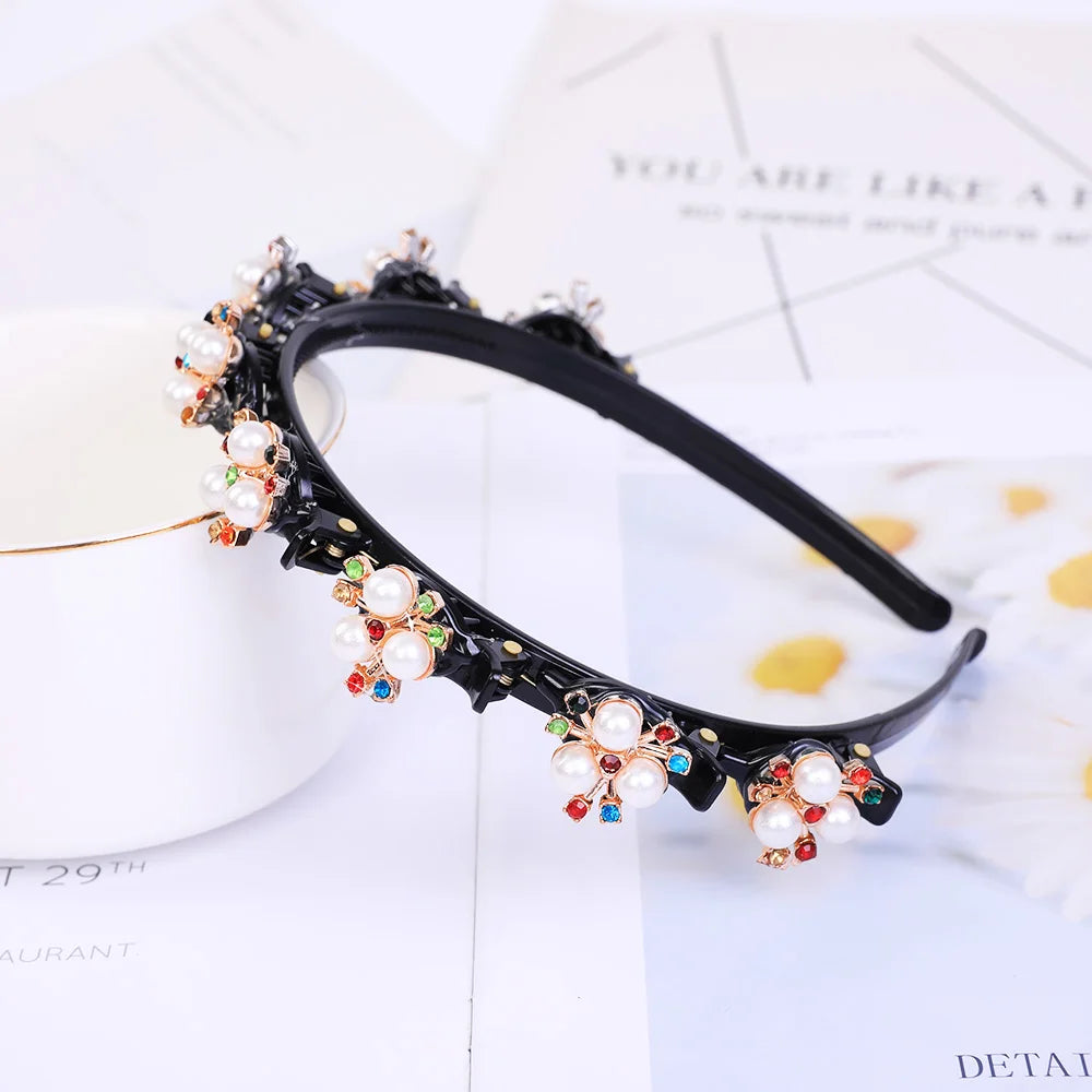 A black headband adorned with white pearls and colorful rhinestones is displayed on a white background.