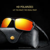 A pair of black sunglasses with orange lenses resting on a black leather case.
