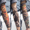 Close-up of a person wearing reusable UV protection tattoo arm sleeves featuring intricate black and orange designs on their 