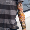 A person wearing a gray t-shirt displays colorful, intricate tattoo arm sleeves on their forearm.