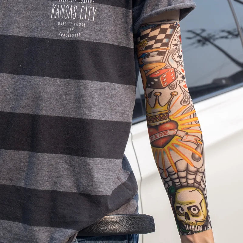A person wearing a gray t-shirt displays colorful, intricate tattoo arm sleeves on their forearm.