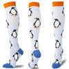 A set of multi-color compression socks featuring penguin designs in black, white, and orange on a white background.