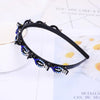 Black headband adorned with blue and clear rhinestones and pearls