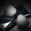 A pair of black polarized pilot sunglasses resting on a dark, textured surface.