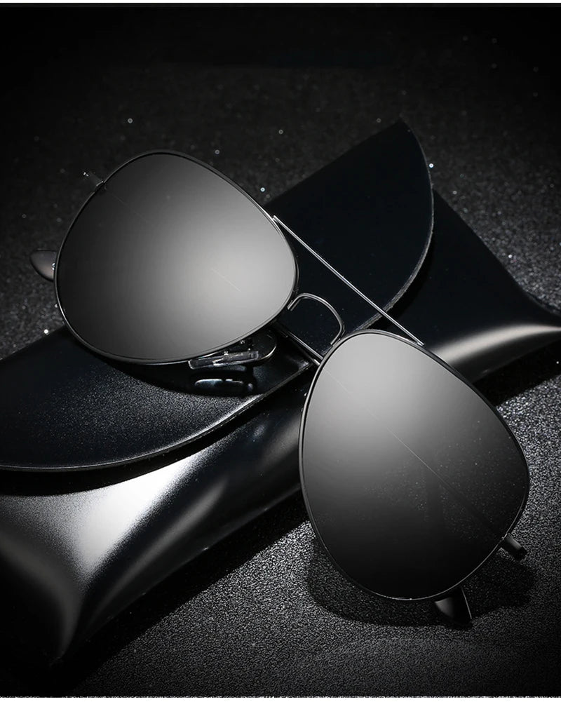 A pair of black polarized pilot sunglasses resting on a dark, textured surface.