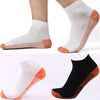 Paire de chaussettes de compression en fibre de cuivre blanc et noir avec des accents orange, vue de côté.