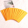 A fan of orange elastic headbands is shown next to a magazine featuring botanical illustrations.