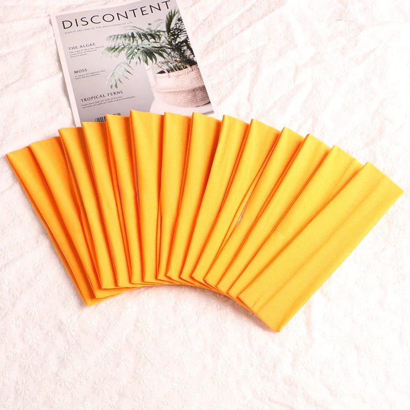 A fan of orange elastic headbands is shown next to a magazine featuring botanical illustrations.