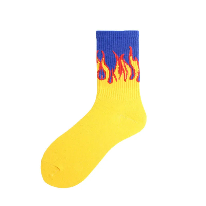 A yellow crew sock with a blue cuff featuring a flame pattern.