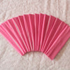A fan of pink elastic headbands arranged in a semi-circle on a white textured surface.