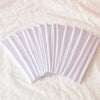 A fan of white elastic headbands folded and displayed on a white textured surface.