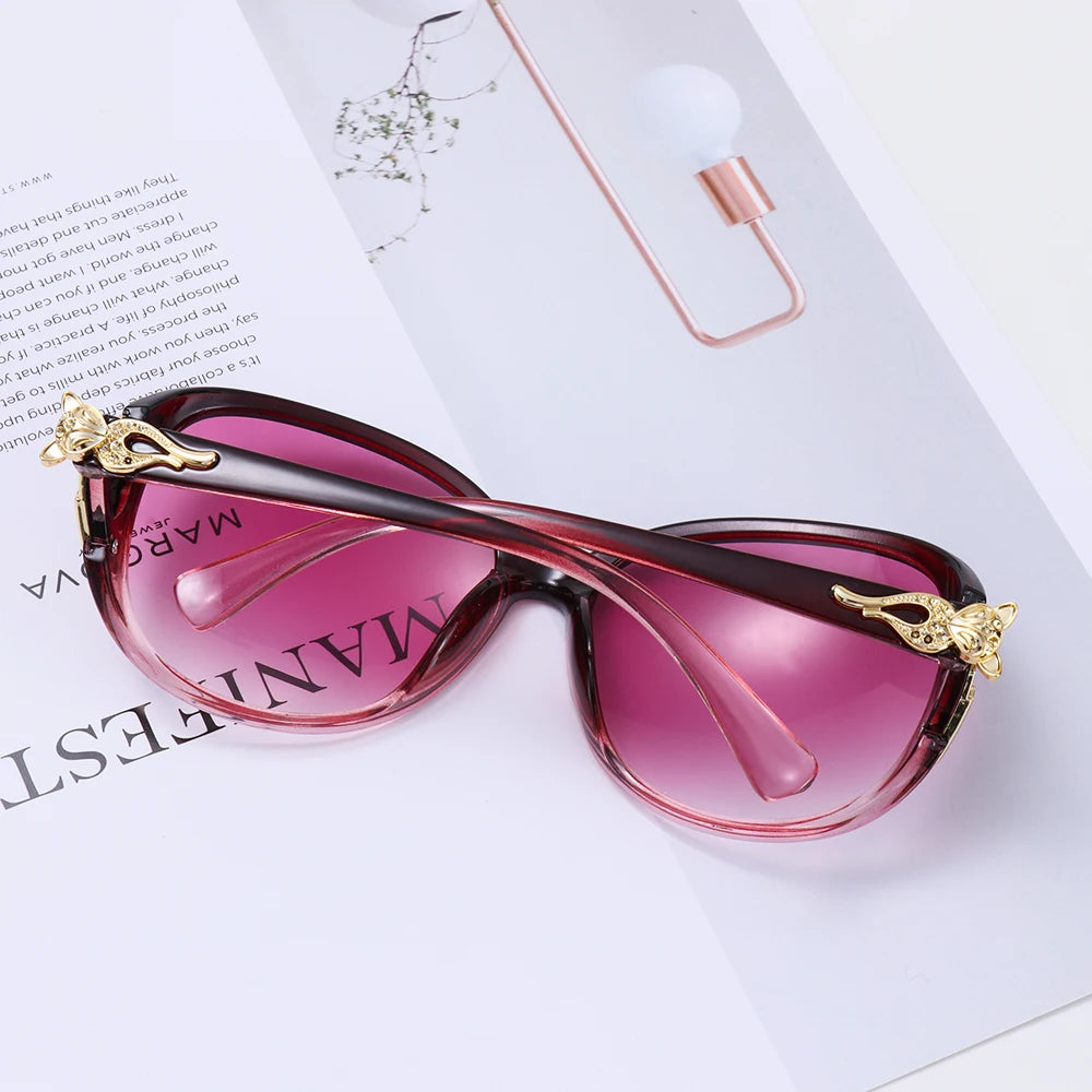 Pink tinted vintage oversized retro sunglasses resting on a white paper with a lightbulb.