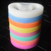 A stack of multi-color silicone elastic wristbands in shades of white, blue, orange, yellow, pink, and teal.