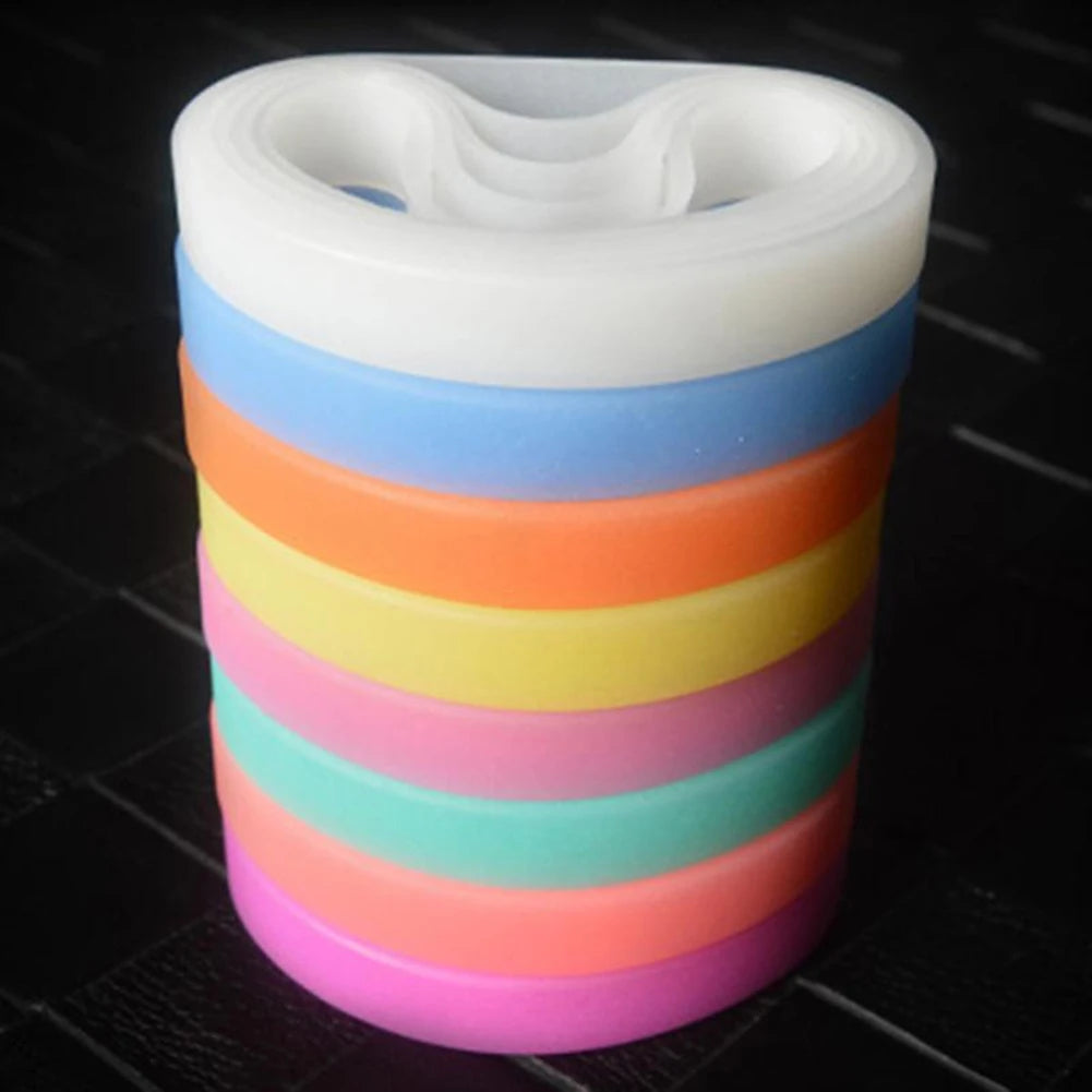 A stack of multi-color silicone elastic wristbands in shades of white, blue, orange, yellow, pink, and teal.
