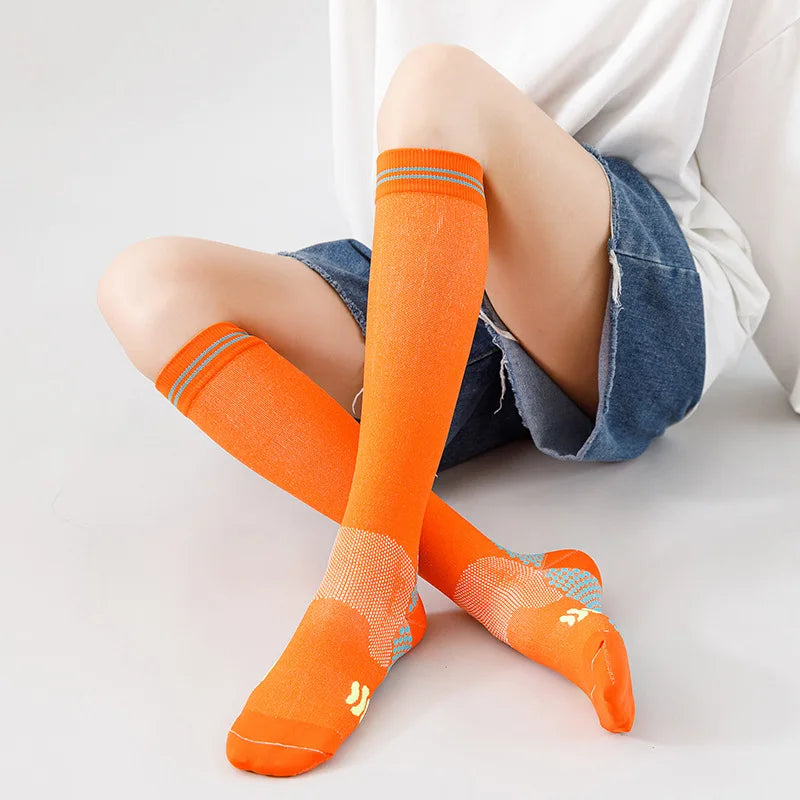Calcetines de compresión médicos naranjas puestos en los pies y tobillos de una persona.