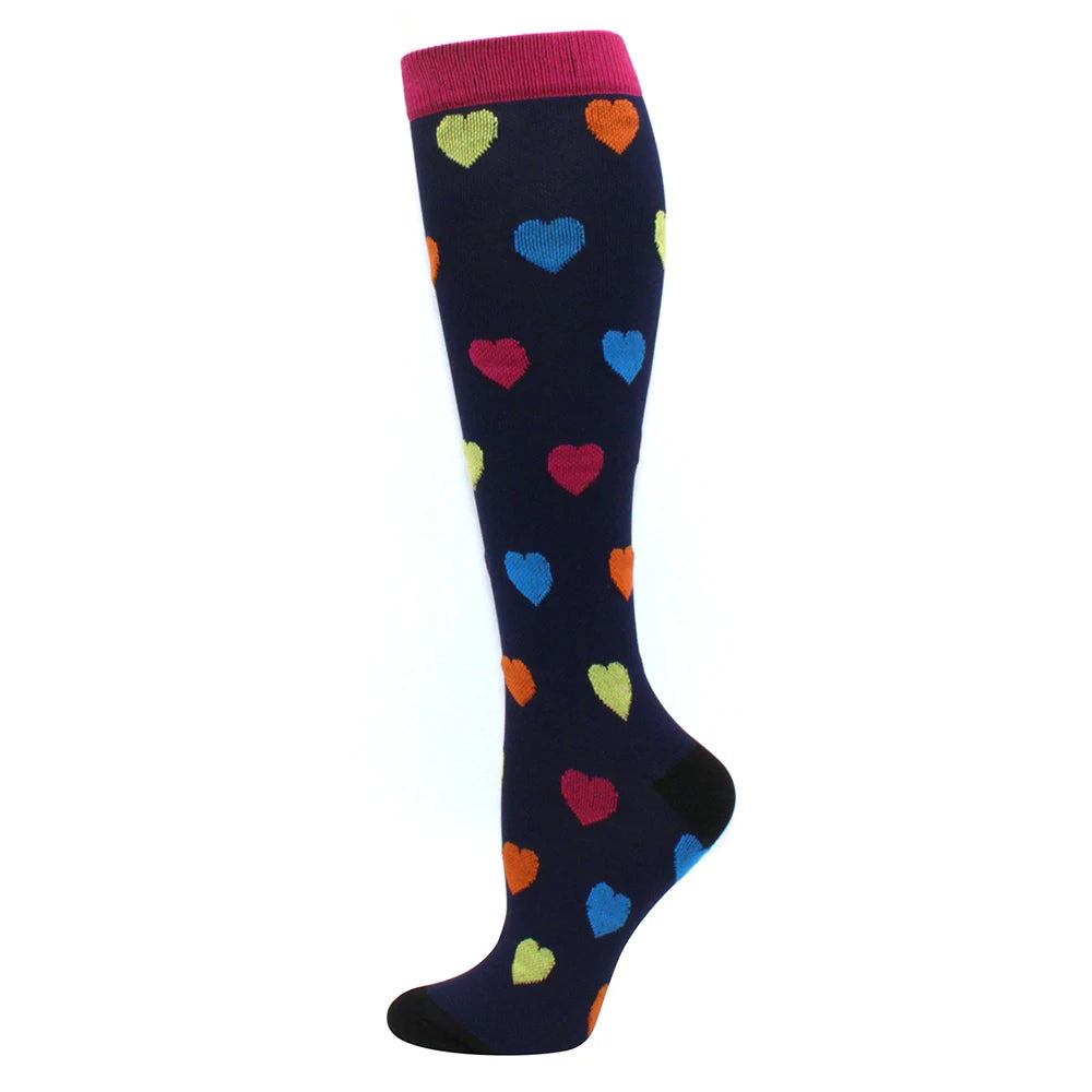A pair of navy blue compression socks with multicolored heart patterns and a pink cuff.