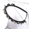 Black headband adorned with pink and clear rhinestones and pearls