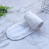 A rolled white exfoliating towel placed on a marble surface.