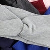 Una pila de bandas para la cabeza de algodón tejido en varios colores, incluyendo gris, granate y azul.