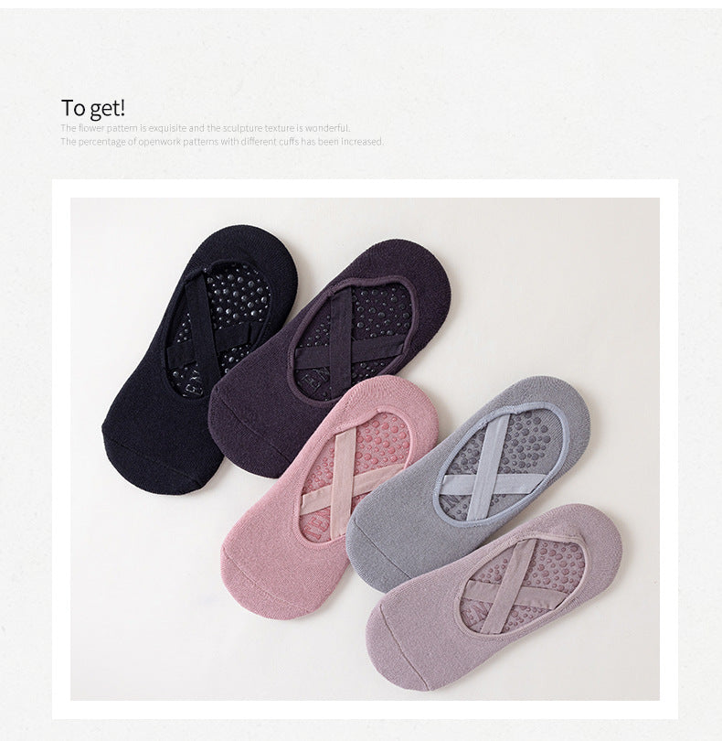 Una colección de cinco calcetines de yoga y pilates ajustados en varios tonos de púrpura, gris y negro.