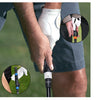 A hand holds a portable golf swing grip trainer, demonstrating its use for practice.