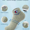A gray ankle sock with a blue embroidered design showing features like threaded opening and soft fabric.