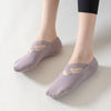 Un par de calcetines de yoga y pilates cómodos color malva puestos en el pie de una persona.