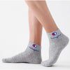 Gray ankle socks with a blue logo featuring the word hemphu