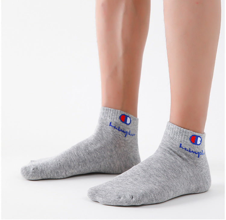 A pair of grey ankle socks with a red and blue logo on the cuff