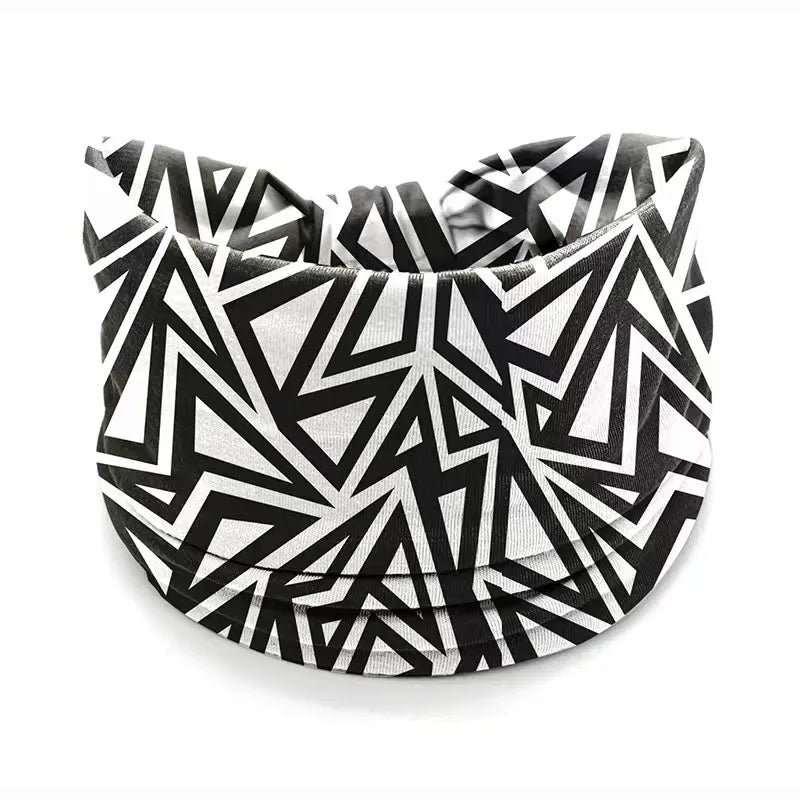 A black and white geometric patterned stretch cotton headband folded in a circular shape.