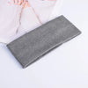 A gray knitted headband is shown next to pink knitted fabric and fingers on a white background.