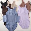 A collection of women's zippered shapewear bodysuits in various neutral and pastel colors.