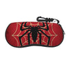 A red fabric pouch shaped like a spider web with a black spider design and a black strap.