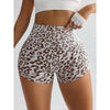 A person is wearing leopard print high-waist seamless shorts and a white cropped top.