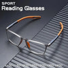 A pair of orange-framed sports reading glasses resting on a dark, textured surface.
