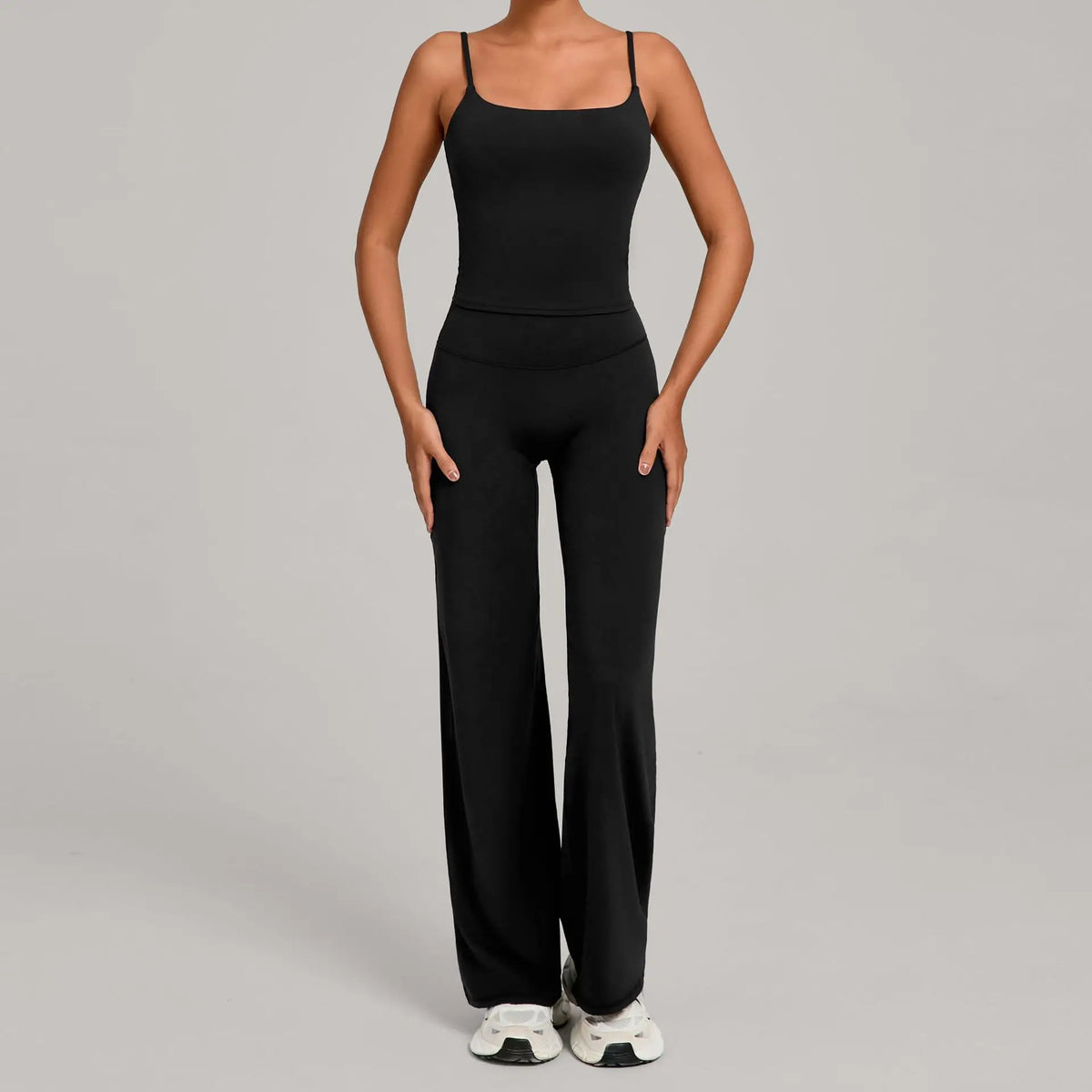 A woman wearing a black high-waist yoga and fitness tracksuit set with matching top and pants.