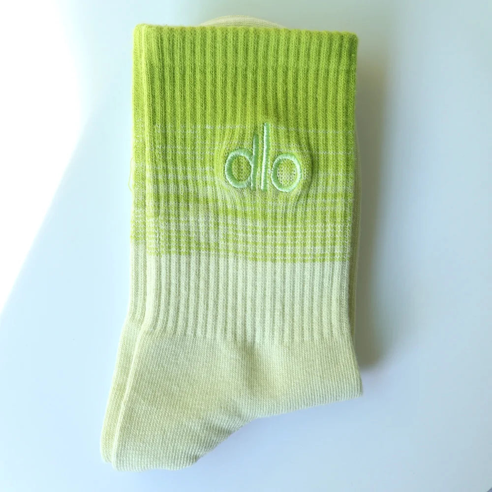 A light lime green knitted sock with a subtle striped pattern and a logo on the toe area.