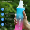 A hand holds a pink sports hydration bottle with a silicone mouthpiece, demonstrating outdoor sports hydration.