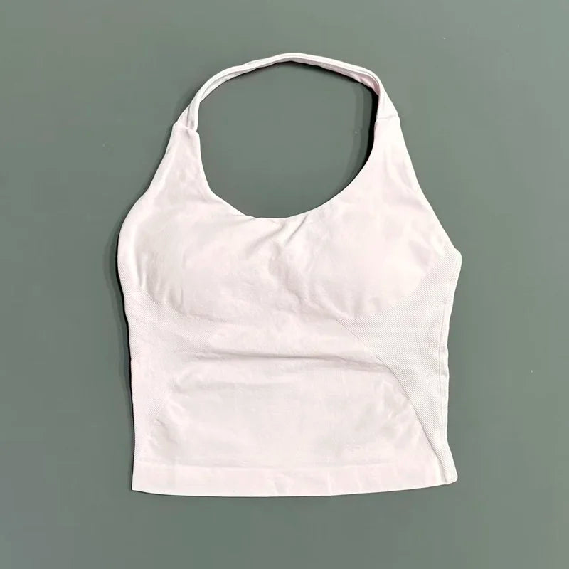 A white seamless performance yoga and gym tank top displayed against a solid gray background.