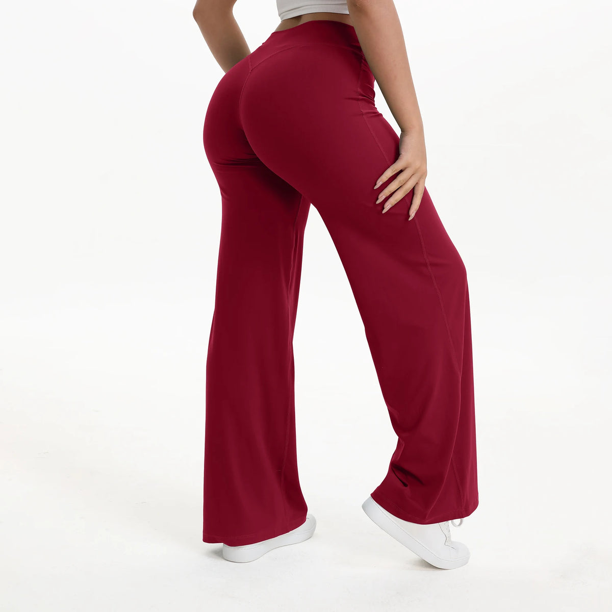 A woman wearing maroon NCLAGEN SoftMotion straight leg yoga pants in a full-length shot.