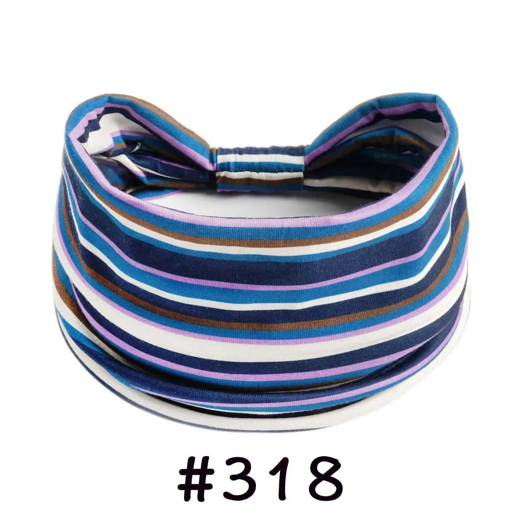 A colorful striped fabric headband tied in a bow, featuring shades of blue, purple, white, and brown.