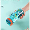A hand holds a clear silicone straw water bottle shaped like a dinosaur for a child.