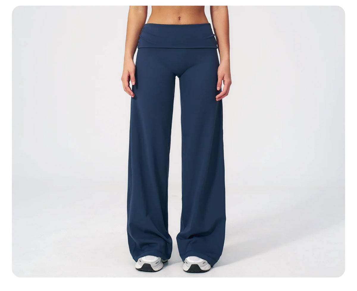 A model wearing dark navy flared high-waist yoga pants in a studio setting.