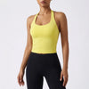 A model wearing a bright yellow seamless yoga and pilates sports bra and black leggings.