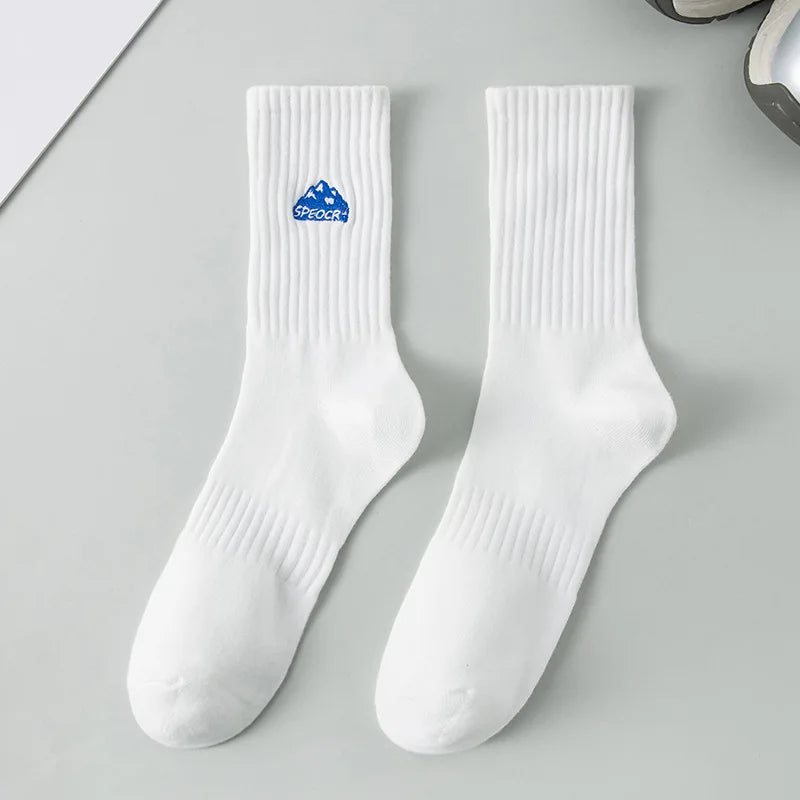 A pair of white men's athletic crew socks with a blue embroidered logo on the foot.
