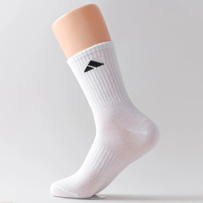 Ein weißer Crew-Socken mit schwarzem geometrischem Muster auf einem hellhäutigen Bein.