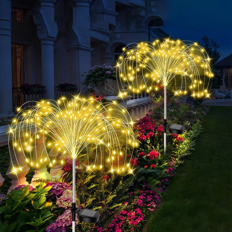 Luces de hadas doradas en una fuente iluminando un camino de jardín exterior por la noche