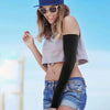 A young woman wearing a light gray top and denim shorts, modeling black sun protection arm sleeves.